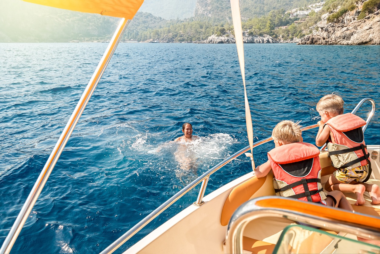 women-wearing-a-life-jacket-while-sitting-on-a-boat
