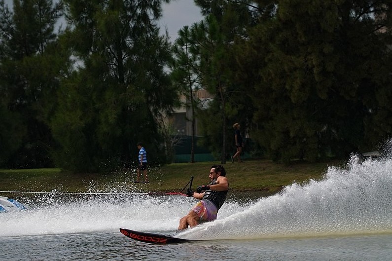 A man slalom skiing by the water