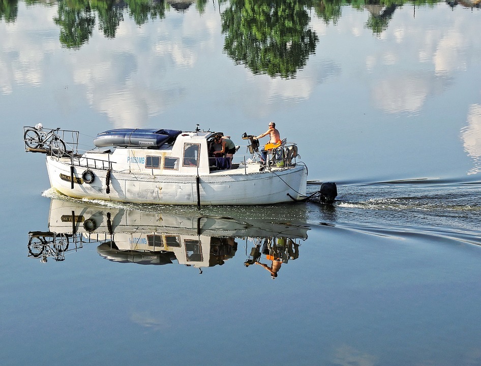 boat, reflection of trees, reflection of clouds, seawater, man and woman on board, bicycle