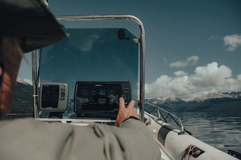 a man on a boat touching the GPS