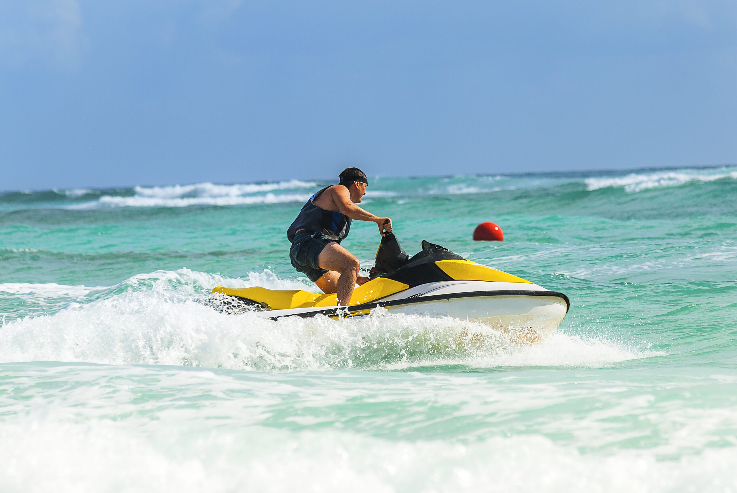 a-man-driving-a-yellow-jet-ski-on-a-clear-ocean