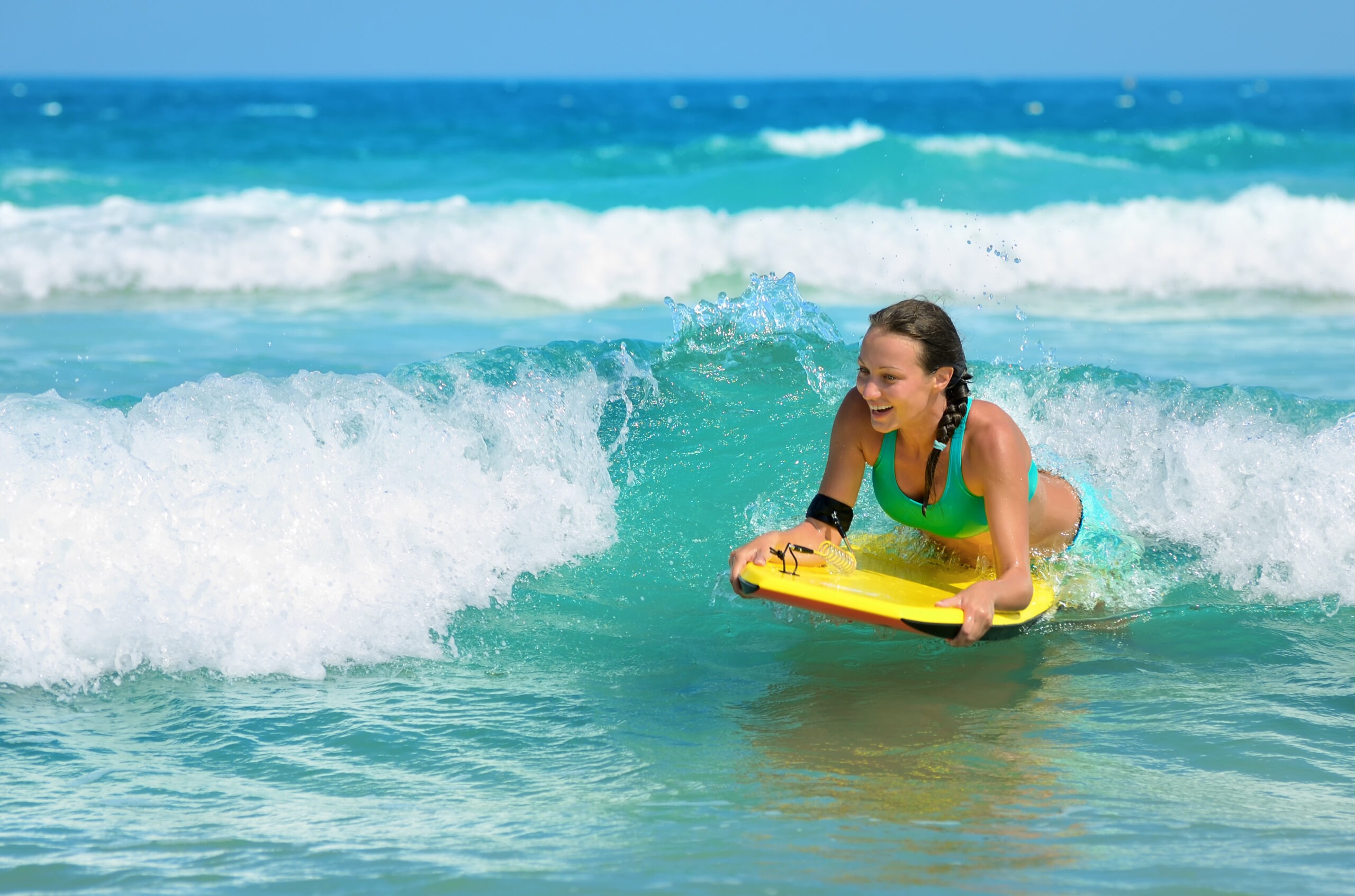 a-woman-smiling-while-bodyboarding