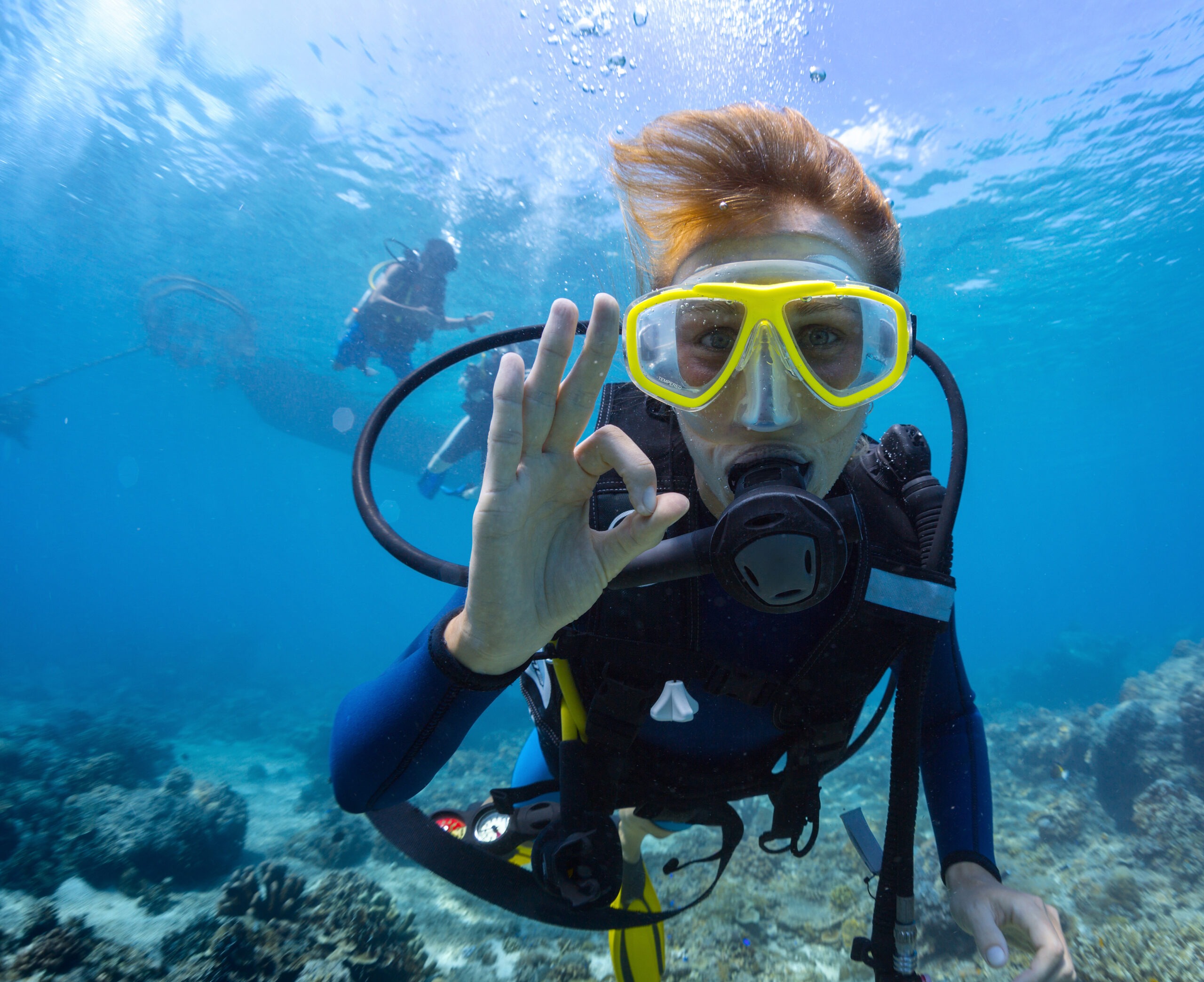 a-female-scuba-diver-underwater-showing-an-“ok”-signal