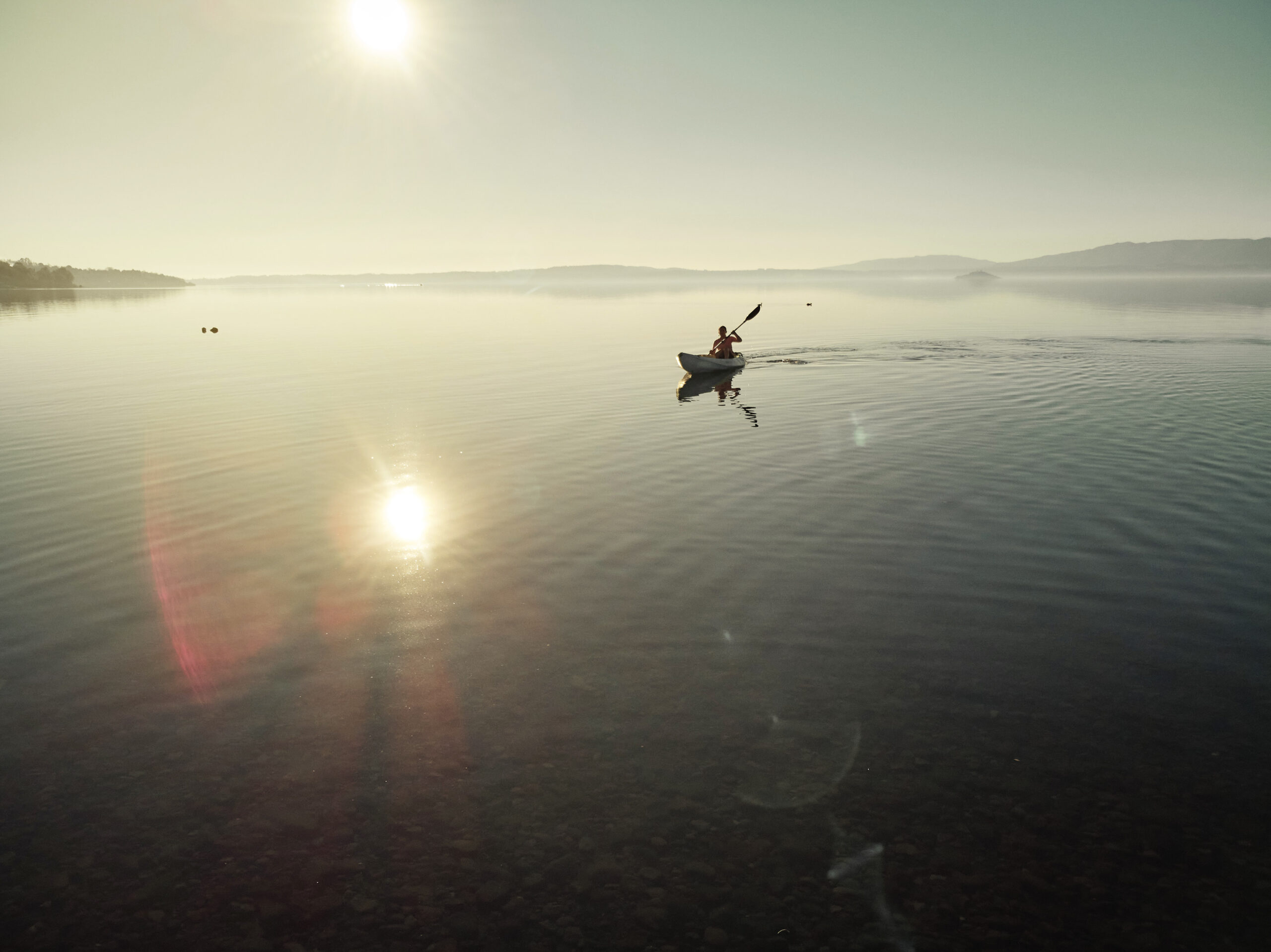 a-woman-kayaking-on-a-calm-lake