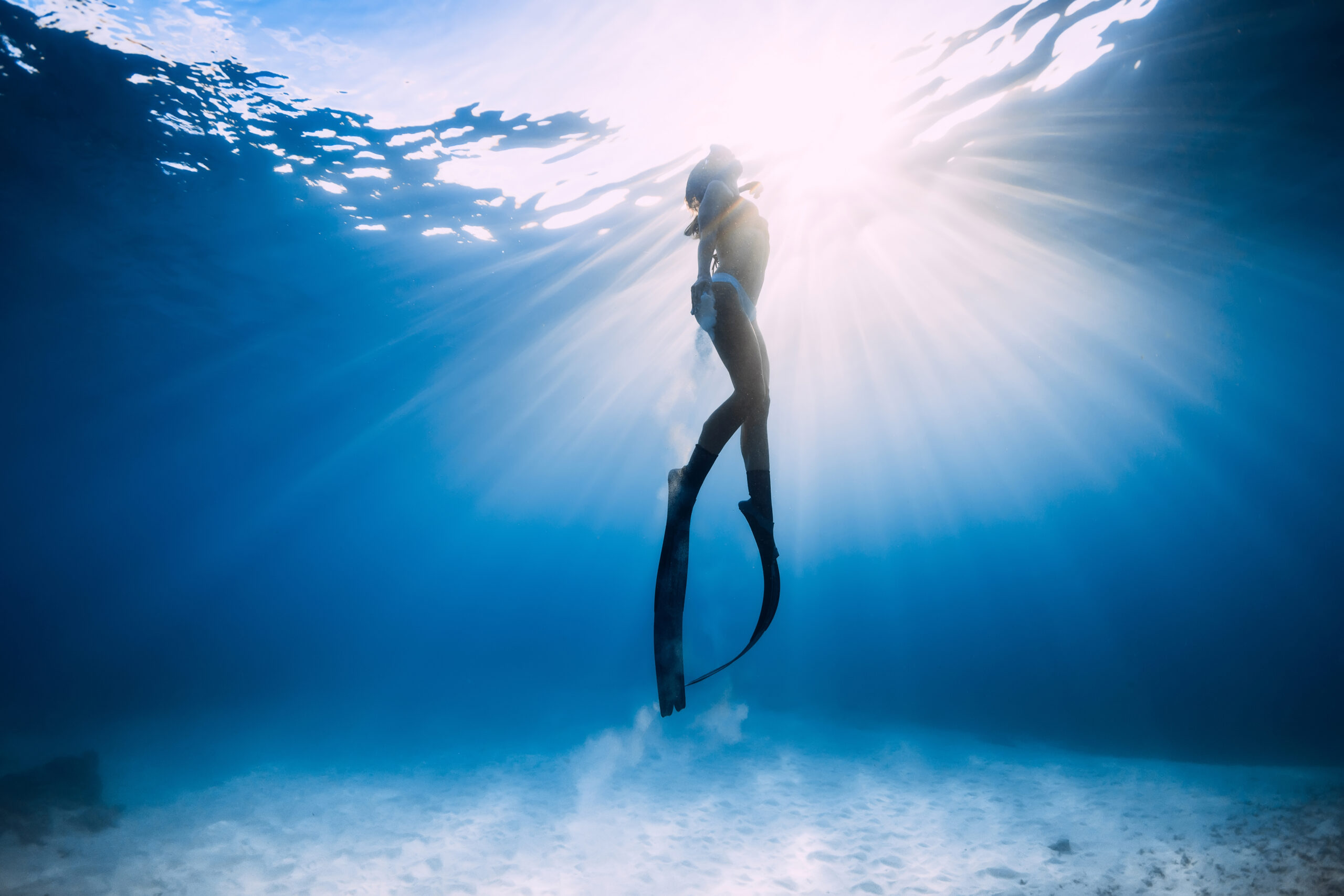 freediver-girl-in-bikini-over-sandy-sea