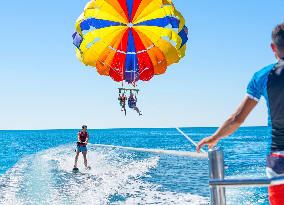 happy-couple-parasailing-in-dominicana-beach-in-summer-couple-under-parachute-hanging