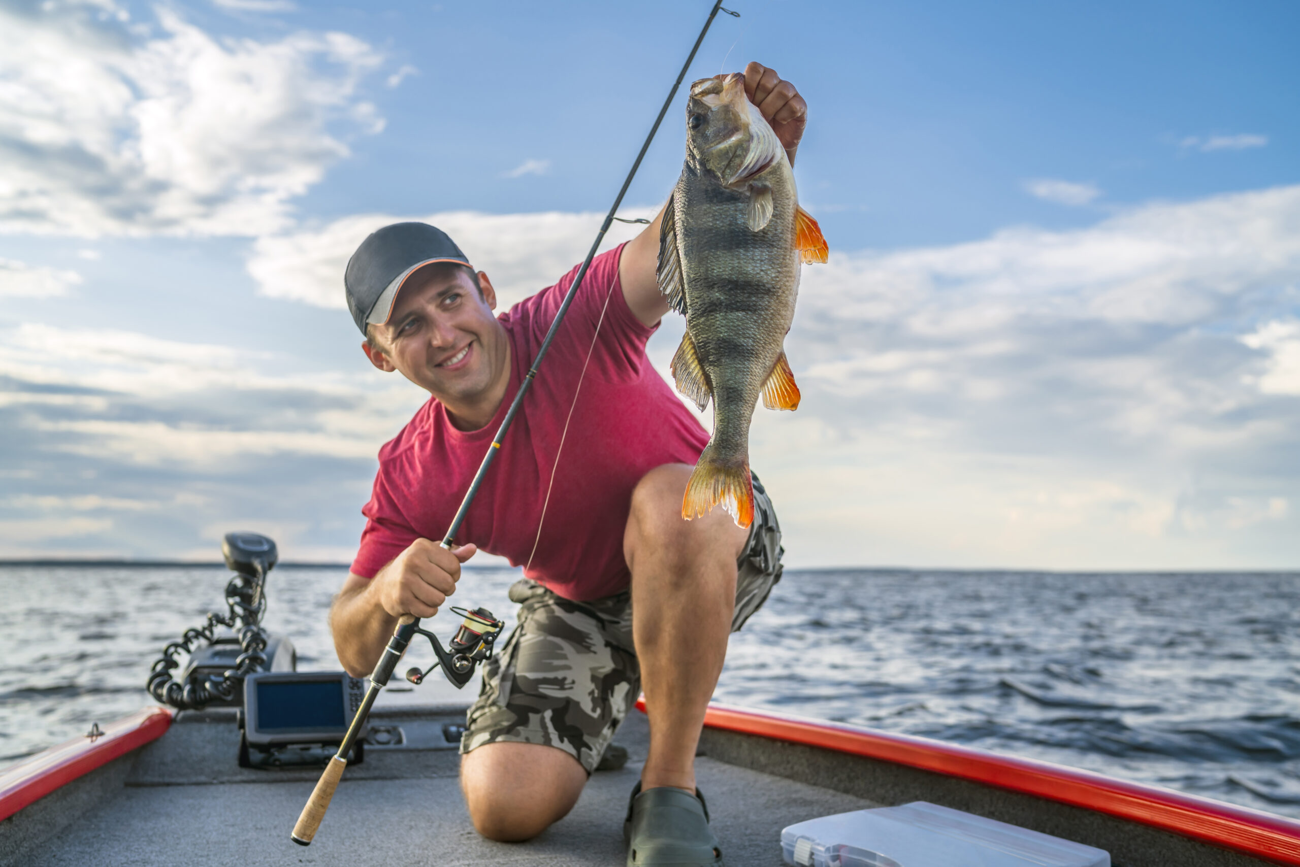happy-fisherman-with-big-perch-fish-trophy-at-boat