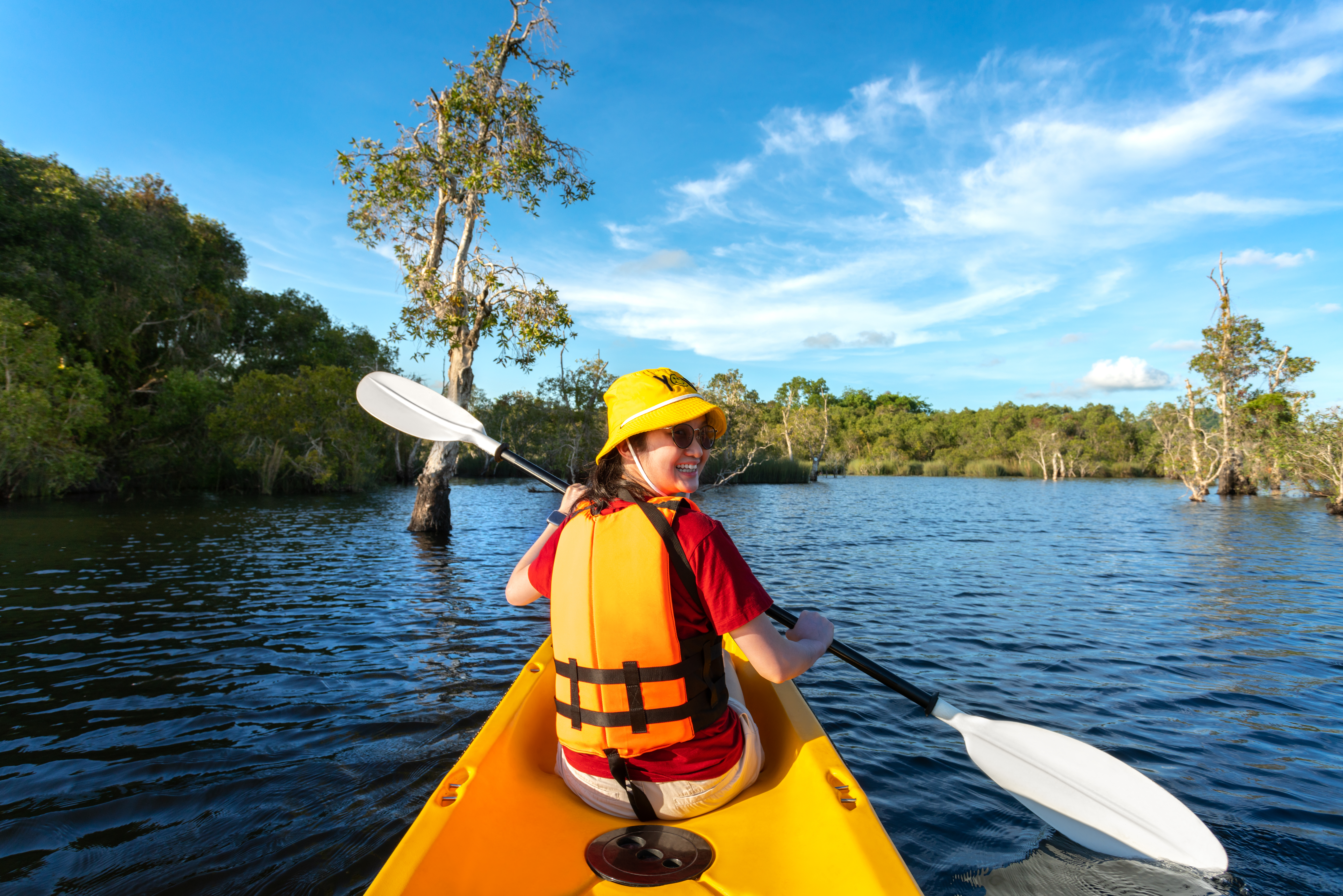 happy-woman-kayaking-with-kayak-boat-in-nuture-lake-behind-sea-and-beach