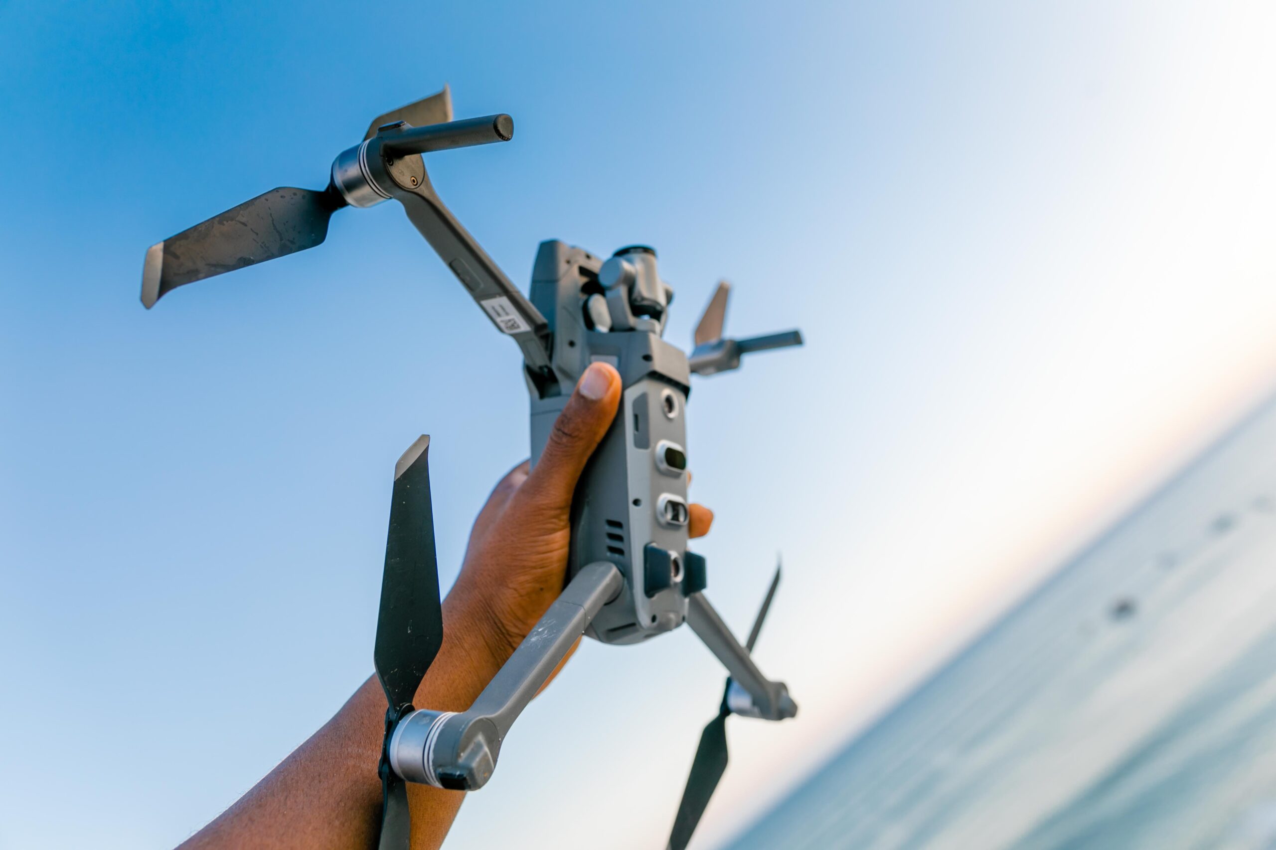 person-holding-gray-quadcopter-drone-scaled