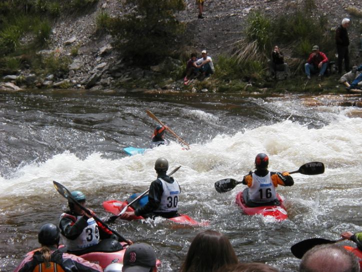 several-people-kayaking-strong-river-flow-people-watching-over-the-kayakers