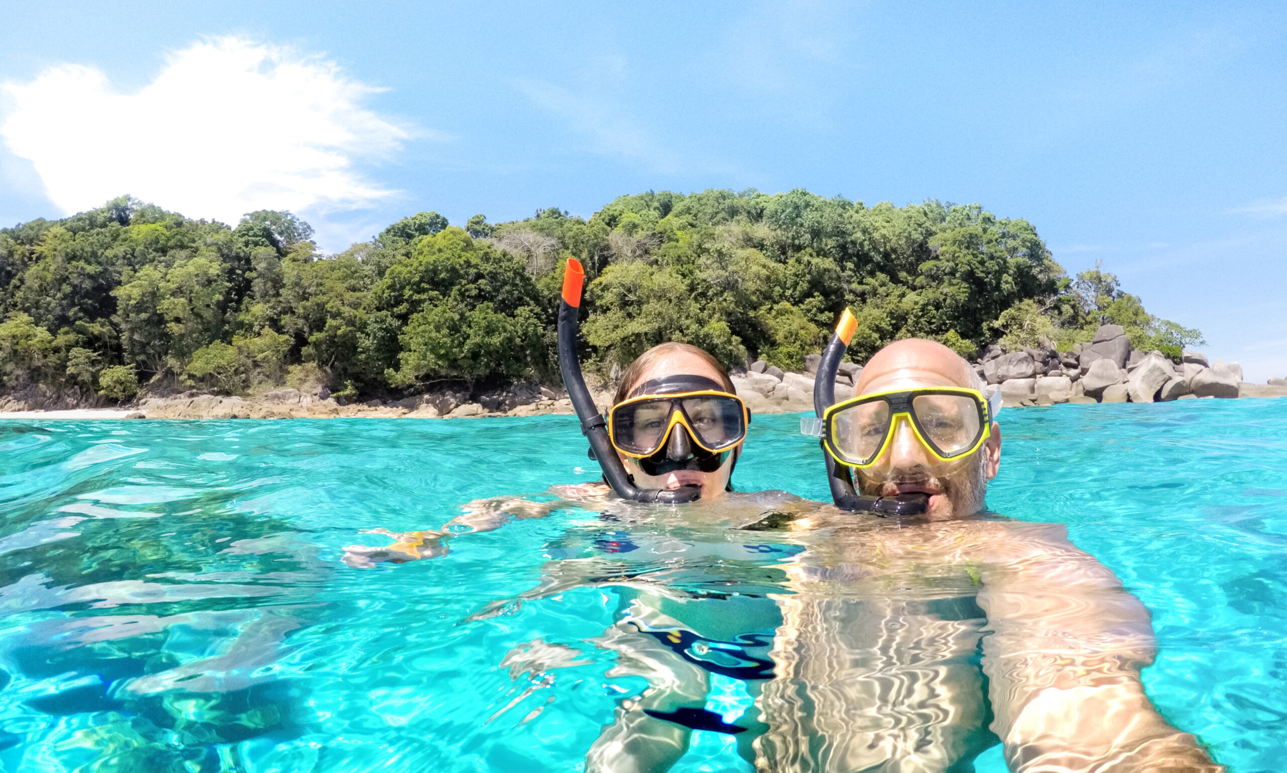 young-couple-taking-selfie-in-tropical-scenario-with-waterproof-camera
